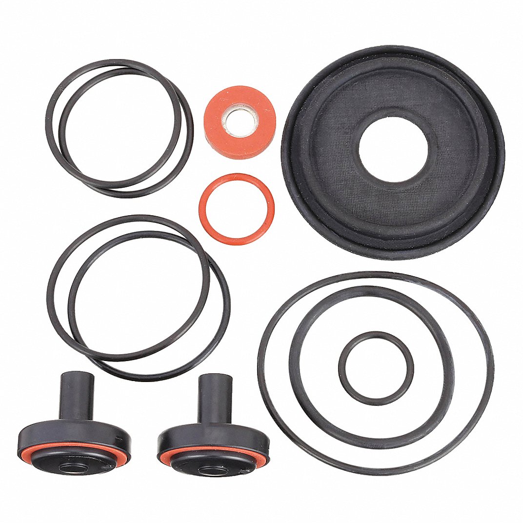 An organized product layout of a Watts Series 009 complete rubber parts repair kit from image_8e153f.jpg, displaying a large black rubber relief valve diaphragm, two black rubber check discs with orange center plates, and a comprehensive array of black sealing O-rings isolated on a flat white background.