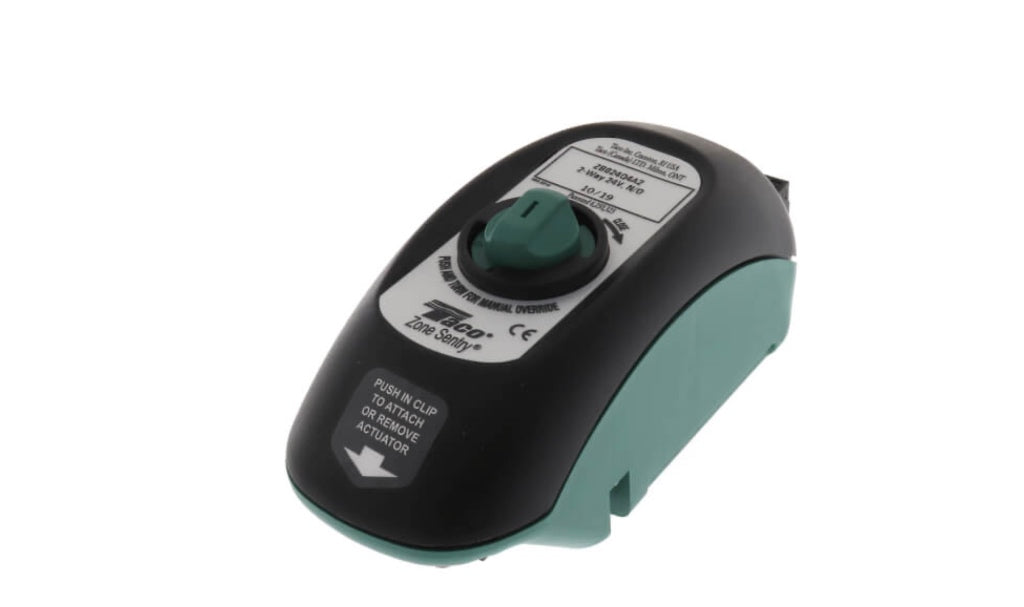 Angled overhead view of the standalone Taco ZB024Q4A2 Normally Open replacement actuator head showing its black shell with a green manual override arrow dials, white tech spec labeling overlay, and teal-blue alignment track base.
